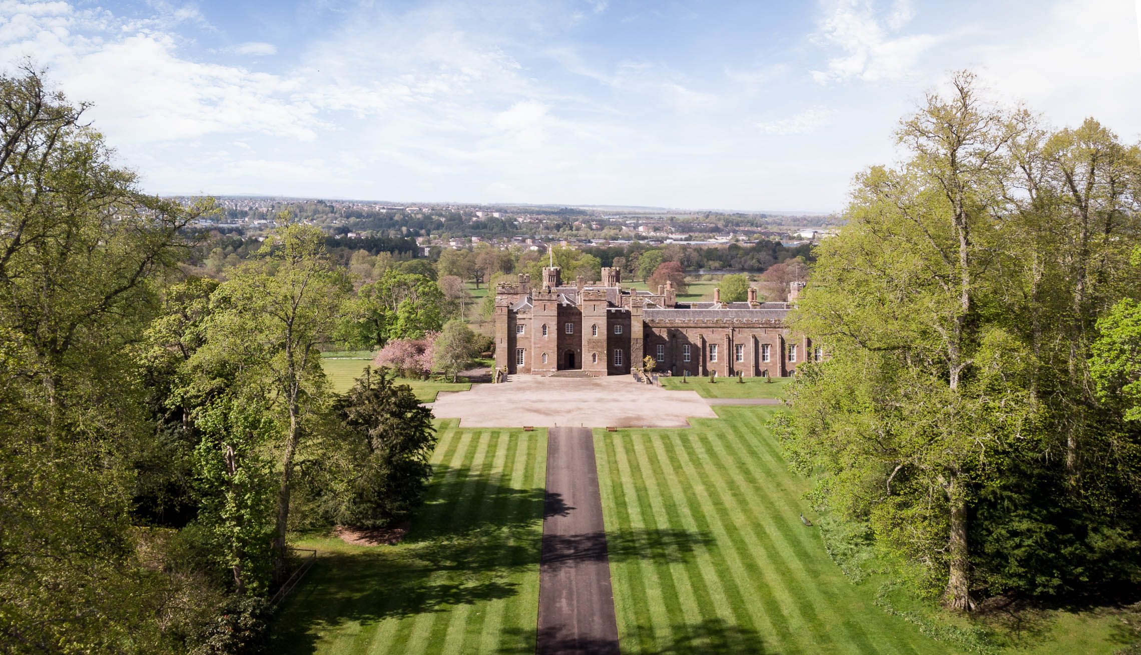 Aerial drone architectural photo of palace surrounded by trees