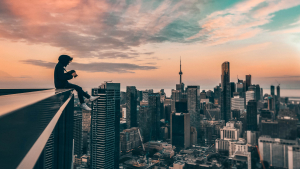 Photographer sitting at top of building looking over cityscape