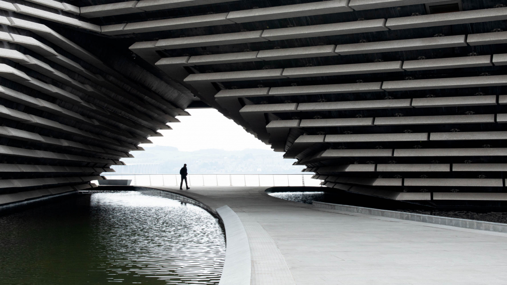 silhouette person walking through tunnel under V and A building Dundee